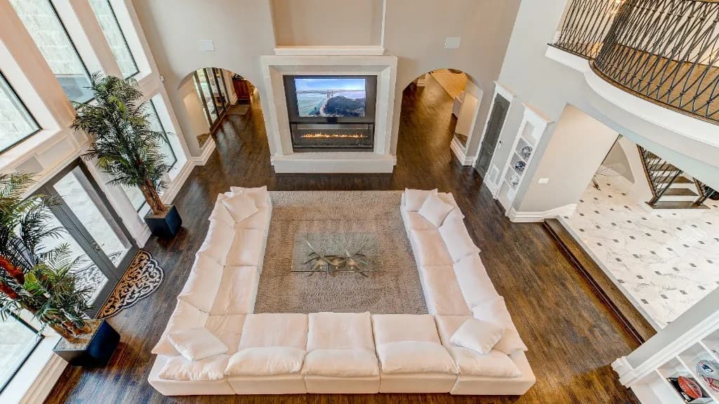 Luxurious modern villa interior featuring a grand double-height living room with a massive white sectional sofa, elegant woodwork, and expansive design.