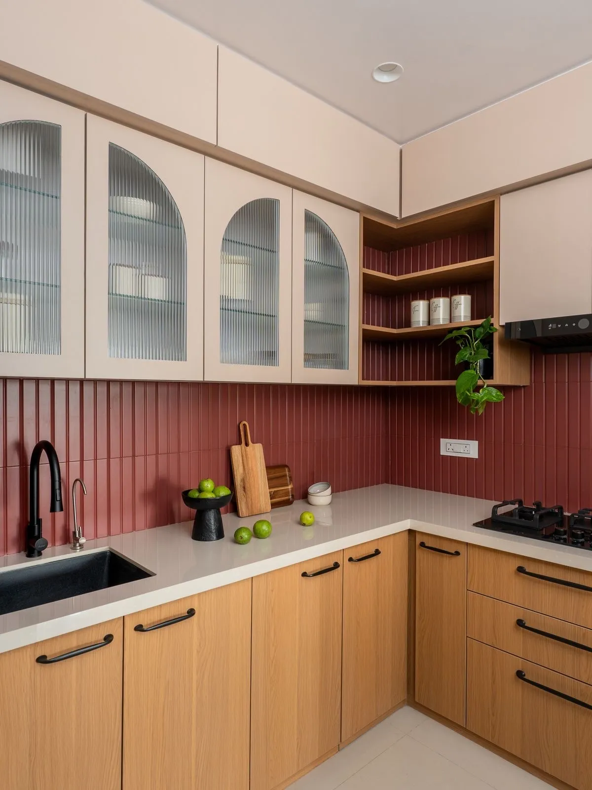 Oak kitchen with a vivid red fluted backsplash and arched glass cabinets
